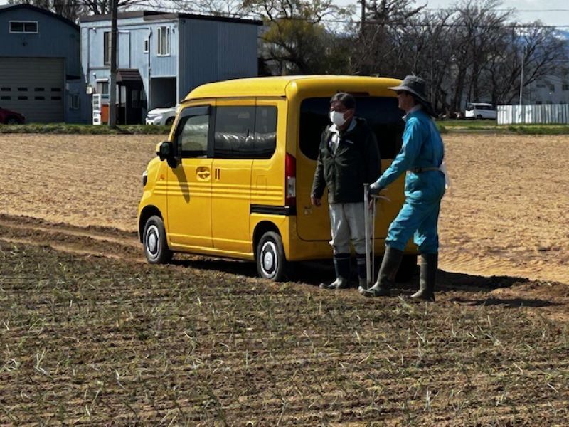 写真２ 作業状況を確認する農業者と専門普及指導員（左）