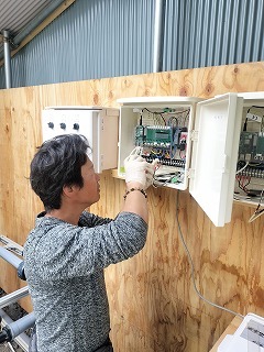 写真1  環境制御装置を設置する田代さん