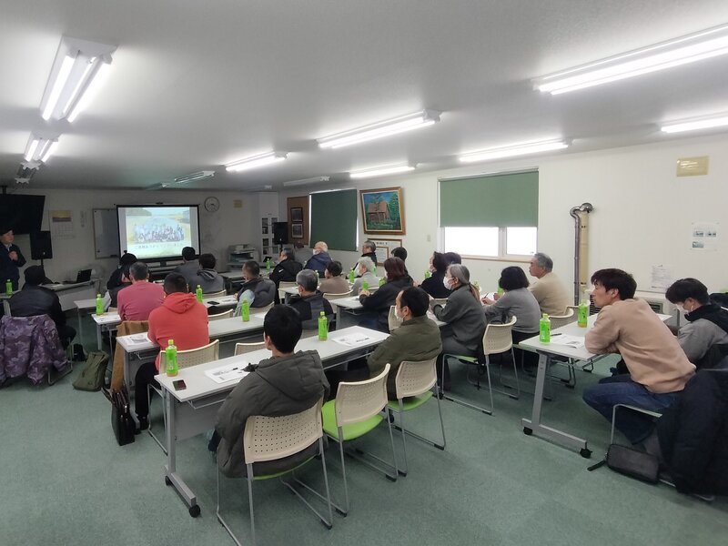 写真1 今年の野菜栽培にむけ真剣な表情で話を聞く参加者。